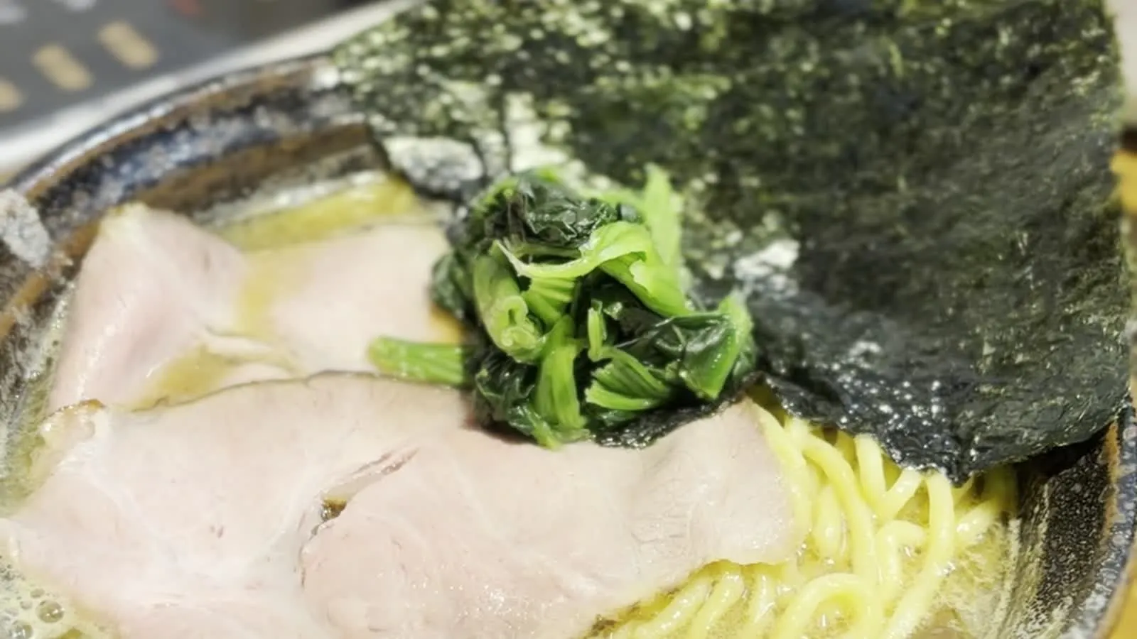 Tonkotsu ramen bowl at みなや in Haebaru, Okinawa — chashu, spinach, nori and thick noodles in rich pork-bone broth